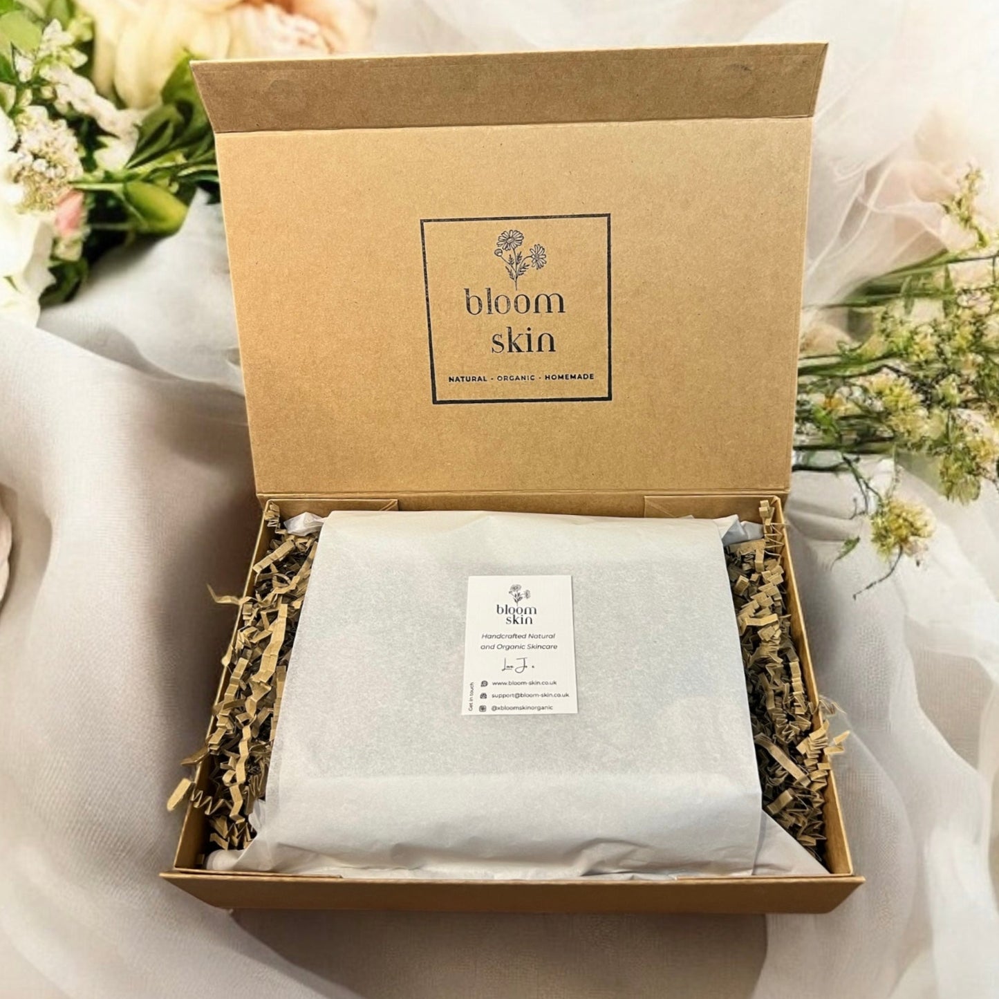 Product packaging with 'bloom skin' branding on a floral background