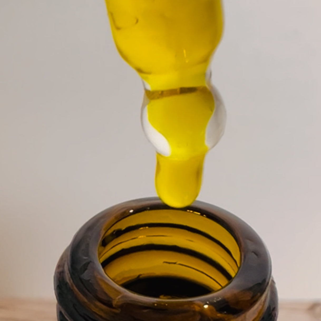 Yellow liquid being poured into a dark brown bottle.