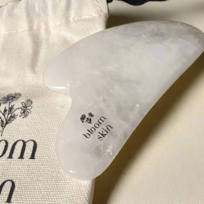 Bloom Skin facial towels and products on a wooden surface
