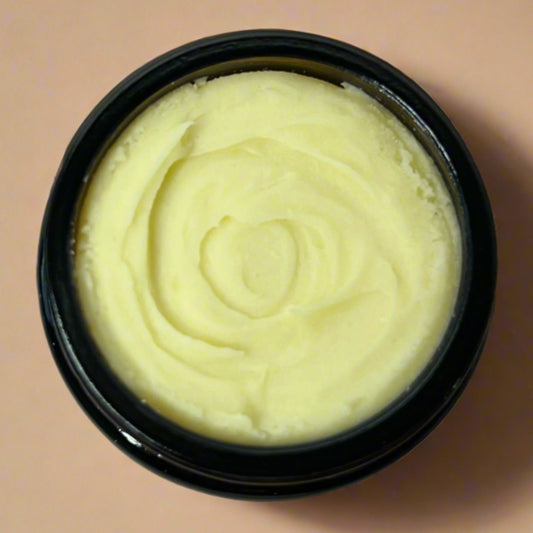 Black container with yellowish cream on a wooden surface