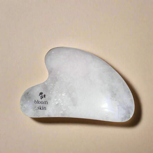 Gua Sha tool on a wooden surface with a white background