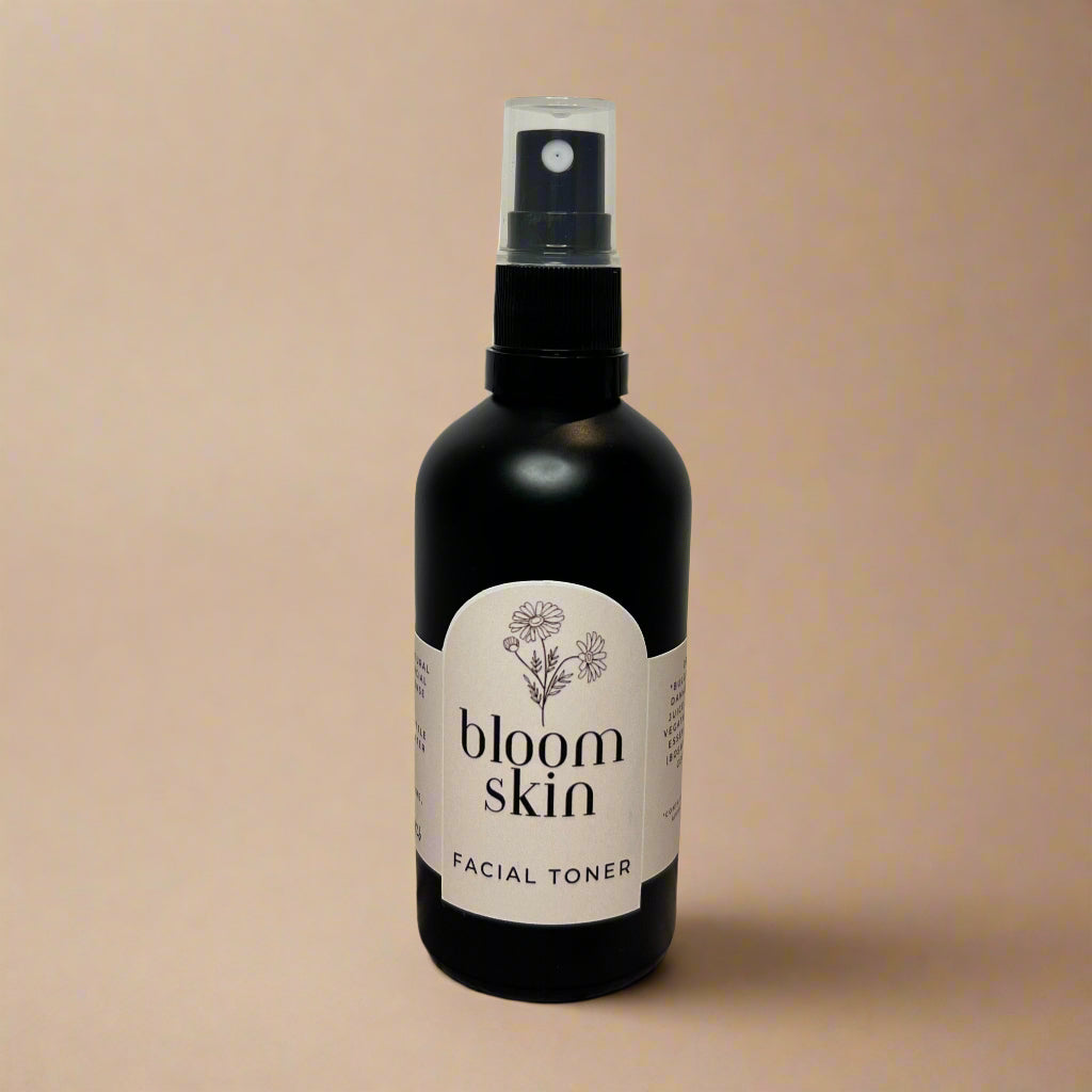 Bottle of 'bloom skin' facial toner on a wooden surface with a white background