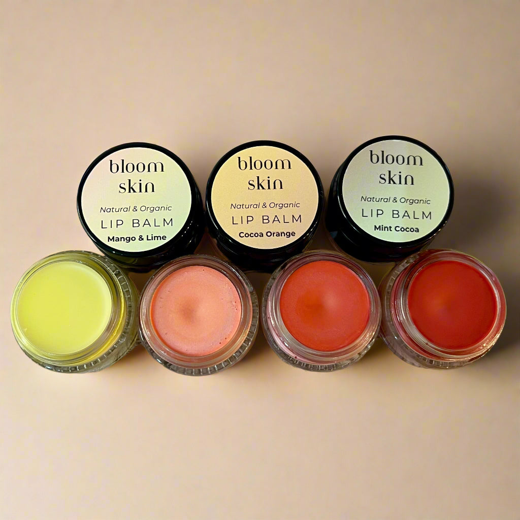 Set of lip balms with 'bloom skin' labels on a wooden surface