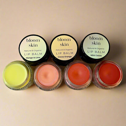 Set of lip balms with 'bloom skin' labels on a wooden surface