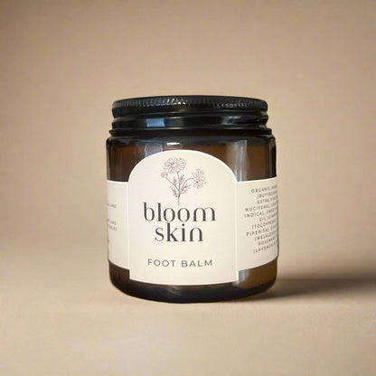 Jars of 'bloom skin' foot balm on a wooden shelf.
